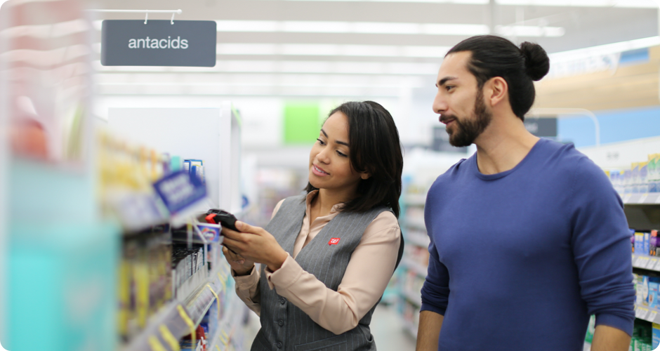 Walgreens employee showing a product to a customers